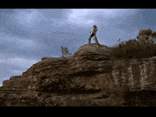 a man standing on top of a rocky cliff