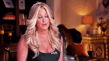 a woman sitting in a chair with her eyes closed says duh