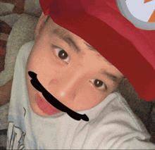 a young boy wearing a red hat with a white circle on it