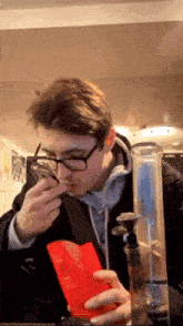 a man with glasses is smoking a bong