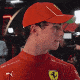 a man wearing a red hat and a red shirt with ferrari on it