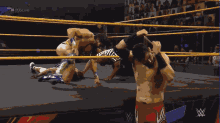 a man in a wrestling ring with # 205live written on the screen