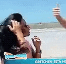 a man and a woman are standing on a beach .