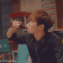 a man drinking from a bottle with a label that says ' coca cola '