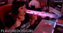 a woman wearing headphones and a shirt that says flavoredonigiri is sitting in front of a computer