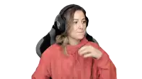 a woman in a red hoodie is wearing headphones and giving an ok sign