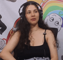 a woman wearing headphones is sitting in front of a cartoon drawing