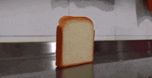 a slice of bread is sitting on a counter in front of a wall .