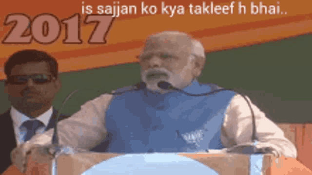 a man is giving a speech in front of a microphone and the year 2017 is behind him