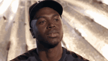 a close up of a man wearing a hat that says l on it