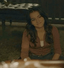 a young woman is sitting on the floor and smiling .