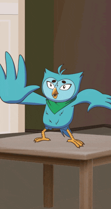 a blue bird with a green scarf around its neck stands on a table