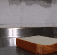 a stainless steel counter top with a piece of bread on it