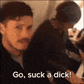 a man with a mustache says go suck a dick while another man looks on
