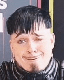 a man with a beard is making a funny face with his eyes closed .