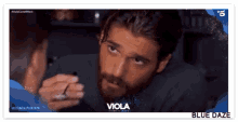 a man with a beard is looking at another man 's face in a viola advertisement