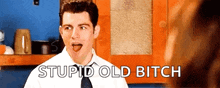 a man in a white shirt and tie is making a funny face and says stupid old bitch .