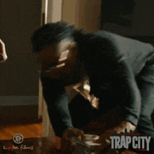 a movie poster for trap city shows a man in a green shirt