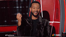 a man sitting in a chair with a nbc logo on the bottom right