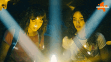 two girls looking at a light with a nickelodeon logo in the background