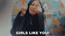 a woman giving the middle finger with the words girls like you behind her