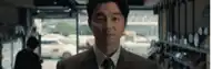 a man in a suit and tie is standing in a store looking at the camera .