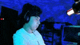 a man wearing headphones and a headband is sitting in front of a computer screen with a youtube logo in the corner