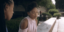 a girl in a pink off the shoulder top sits next to another girl in a netflix ad