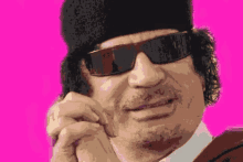 a pixelated image of a man wearing sunglasses and a hat on a pink background