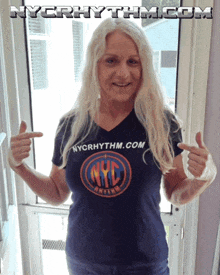 a woman wearing a nyc rhythm t-shirt points to herself