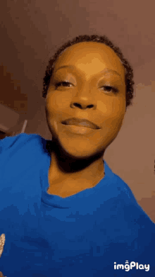 a woman in a blue shirt is making a funny face