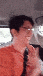 a blurry photo of a man wearing glasses and a red shirt