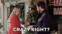 a man and a woman are standing in front of a christmas tree and the man is saying crazy right .