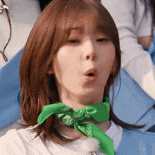a close up of a woman wearing a green bandana around her neck