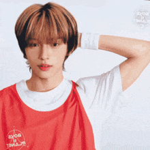 a young man wearing a red and white t-shirt that says 2x05 on it