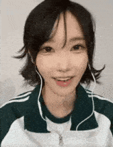 a close up of a girl wearing headphones and a jacket .