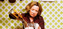 a woman is pouring a bottle of tequila into a glass of ice .