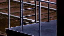 a staircase with a railing and a ladder going up it