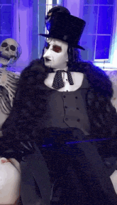 a man in a top hat and fur coat is sitting next to a skeleton .