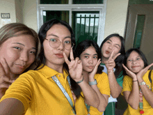 a group of girls posing for a picture in front of a sign that says exit