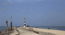 a pier with a lighthouse in the distance