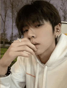 a young man wearing a white hoodie with chinese writing on the front