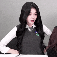 a girl with long black hair wearing a vest and tie with a badge that says ' seoul ' on it