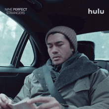 a man sitting in a car with hulu written on the bottom