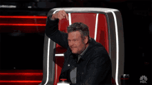 a man sitting in a chair with nbc written on the bottom