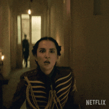 a woman in a military uniform is standing in a hallway with netflix written on the bottom