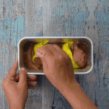a person is scooping ice cream into a white container