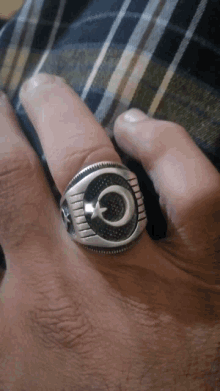 a man wears a silver ring with a crescent moon and star on it