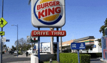 a burger king drive thru sign with a truck in the background