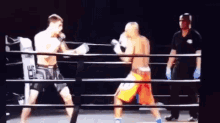 two men are boxing in a ring with a referee and a sign that says ' ufc ' on it